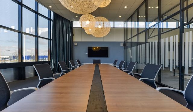 Moderne vergaderzaal met presentatiescherm: Een goed uitgeruste vergaderruimte met een groot scherm voor presentaties, ideaal voor zakelijke bijeenkomsten en presentaties.